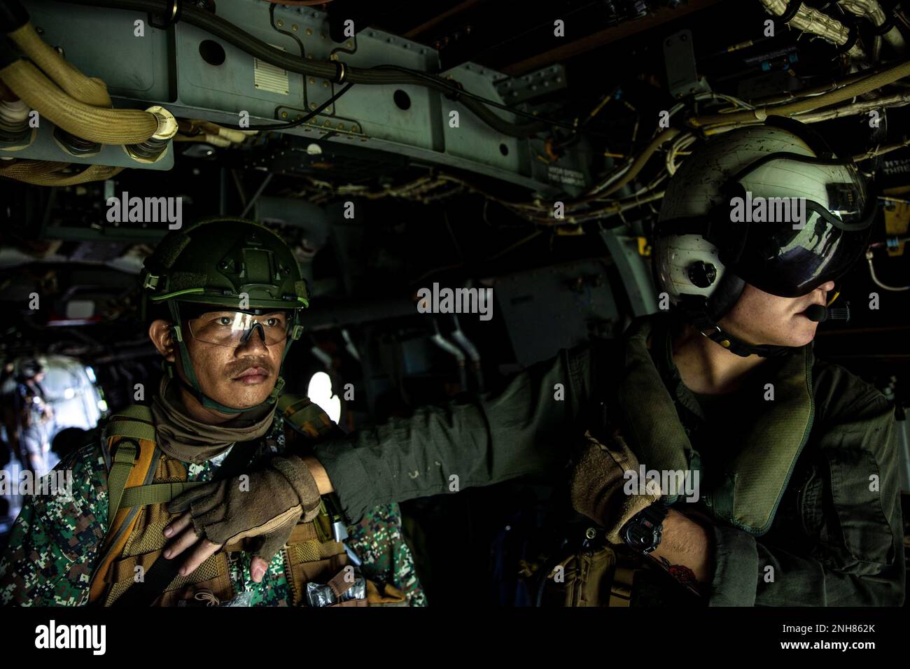 USA Marinekorps Sgt. Jenna Yarrington, MV-22 Tiltrotor Crew Chief mit Marine Medium Tilt-Rotor Squadron (VMM) 265, und ein philippinischer Marine Look auf der Rückseite eines MV-22b während Marine Aviation Support Activities 22-2, 21. Juli 2022, Subic Bay, Philippinen. MASA 22-2 ist eine bilaterale Übung zwischen den Streitkräften der Philippinen und den USA Marine Corps, das darauf abzielt, die Interoperabilität zu erhöhen und die Fähigkeiten im Bereich der Luftfahrt zu verbessern, um die gegenseitige Verteidigung zwischen den USA und den Philippinen zu unterstützen. Stockfoto