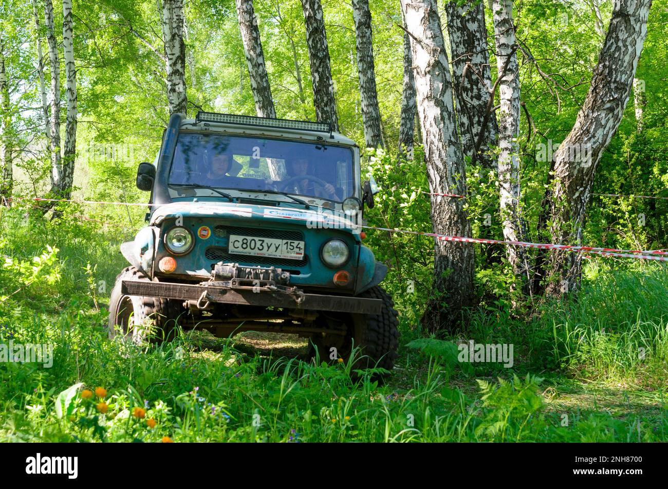 Russische Militärfahrzeuge der UAZ mit schützendem Gummistoßfänger und Schlammfahren im Wald in Russland Stockfoto