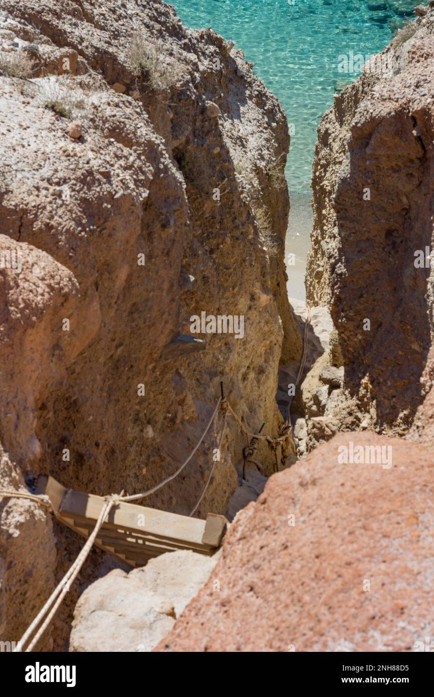 Schmale Passage mit Holzleiter zum Strand von Tsigrado, Milos Stockfoto