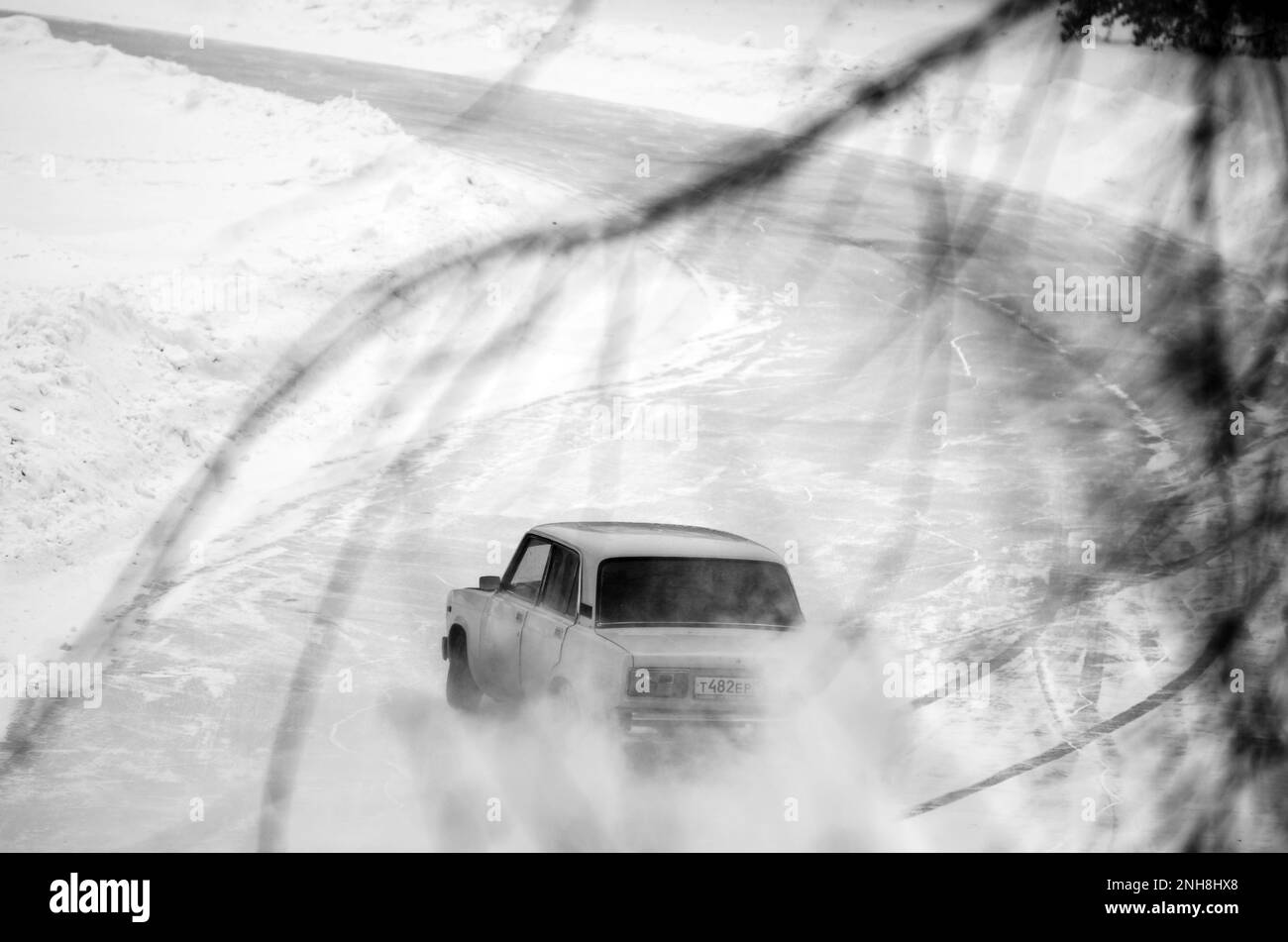 Russische Altautos „VAZ Zhiguli“ fahren schnell in einer Drift auf einer verschneiten Straße. Stockfoto