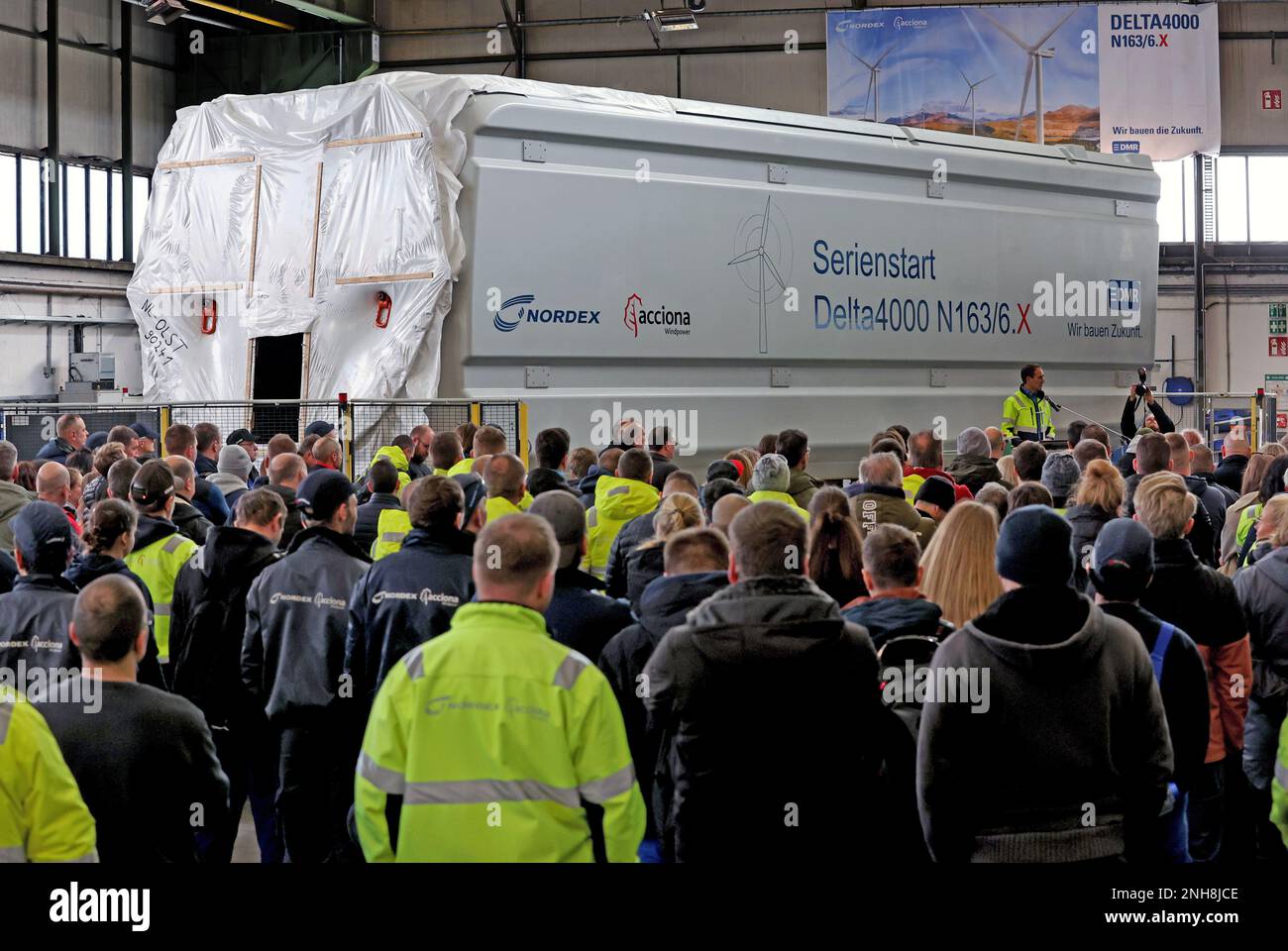 Rostock, Deutschland. 21. Februar 2023. Bei Nordex Energy beobachten die Mitarbeiter den feierlichen Beginn der Serienproduktion der 6-MW-Turbinen. Langfristig werden jährlich bis zu 150 der Gondeln gebaut, die fast 13 Meter lang und 7 Meter hoch sind und über 70 Tonnen wiegen. Kredit: Bernd Wüstneck/dpa/Alamy Live News Stockfoto