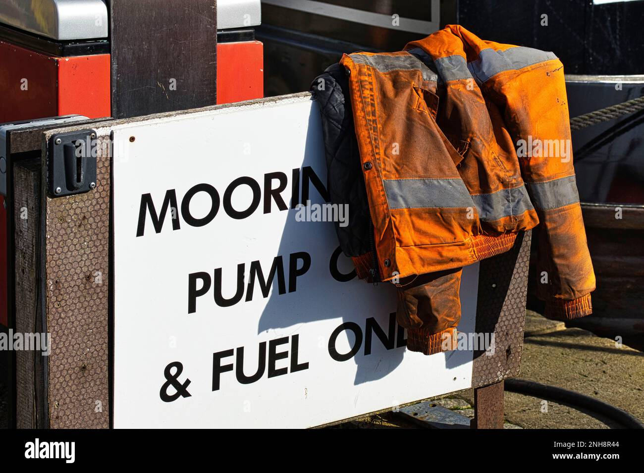 Ölige Hi-Viz Jacke über dem Eingang einer Tankstelle am Kanal Stockfoto