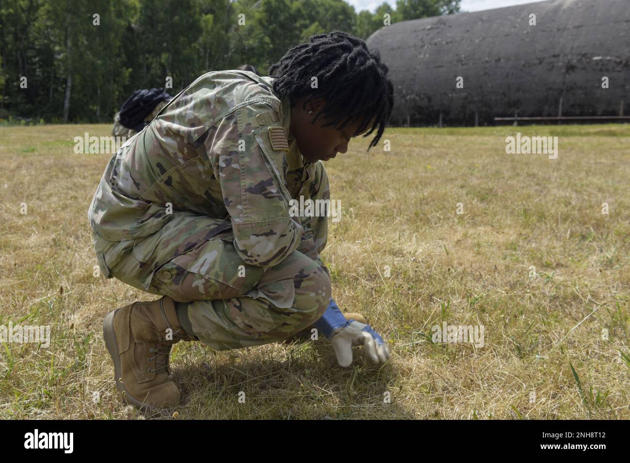 USA Air Force Airman 1. Class Jalitha Twyman, 786. Force Support Squadron Evaluations Technician and Mortuary Affairs Program, durchsucht das Gras während eines simulierten C-130J Super Hercules Flugzeugabsturzes für Übungsoperation Varsity 22-3 auf dem Luftwaffenstützpunkt Ramstein, Deutschland, 27. Juli 2022. Die Aufgabe des Programms für Bestattungsangelegenheiten besteht darin, den Gefallenen würde, Ehre und Respekt zu erweisen und ihren Familien Fürsorge, Dienst und Unterstützung zu gewähren. Stockfoto