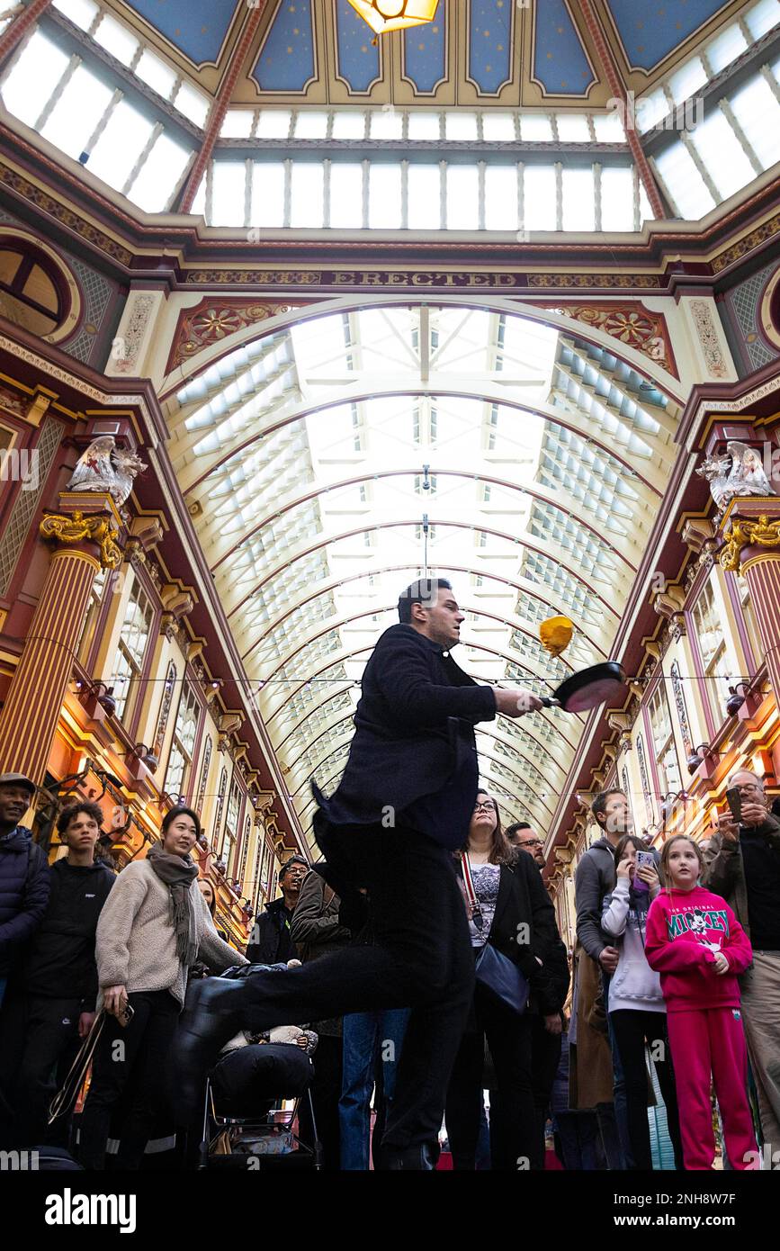 REDAKTIONELLER GEBRAUCH NUR Menschen nehmen am alljährlichen Leadenhall Market Pancake-Rennen Teil, drehen Pancakes, die von der Lamb Tavern zubereitet werden, und konkurrieren um die Trophäe „goldene Pfanne“ in London. Foto: Dienstag, 21. Februar 2023. Stockfoto