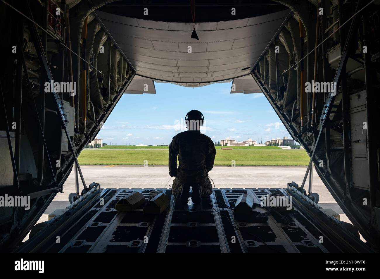 Senior Airman Carson Christian, 36. Airlift Squadron Ladermeister, schaut aus einer offenen C-130J Super Hercules Laderampe. Er hilft Piloten, die das Flugzeug rückwärts auf einen Parkplatz am Yokota Air Base, Japan, am 27. Juli 2022 bringen. Der C-130J Super Hercules führt hauptsächlich den taktischen Teil der Luftschubmission durch. Der C-130J kann von rauen, schmutzabweisenden Streifen aus betrieben werden und ist der erste Transport für die Luftabwurf von Truppen und Ausrüstung in feindliche Gebiete. Stockfoto