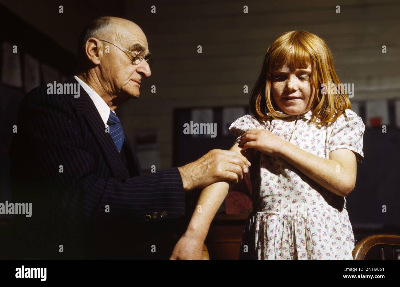 Typhus-Impfung an einer Landschule in San Augustine County, Texas. Typhus, auch als Typhus bekannt, ist eine Krankheit, die durch Salmonella Serotyp Typhi Bakterien verursacht wird und durch Essen oder Trinken von Lebensmitteln oder Wasser mit dem Kot einer infizierten Person verunreinigt wird. Fotografiert von John Vachon, Farm Security Administration, April 1943. Stockfoto