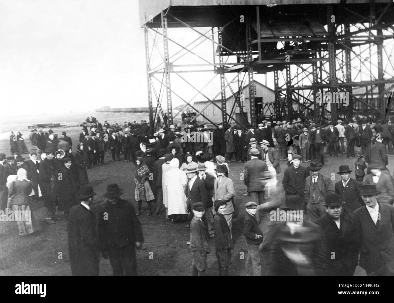 Eine Menge an der Mündung des Schachts der Cherry Mine. Am 13. November 1909 brannte eine Kohlemine in Cherry, Illinois, und tötete schließlich 259 Männer und Jungen, darunter einige Rettungskräfte. 21 Bergleute überlebten acht Tage unter der Erde, nachdem sie eine provisorische Mauer errichtet hatten. Die Katastrophe ist die dritttödlichste in der Geschichte des amerikanischen Kohlebergbaus. Im darauf folgenden Jahr führte der Gesetzgeber von Illinois strengere Vorschriften für die Sicherheit im Bergbau ein; 1911 verabschiedete Illinois ein separates Gesetz, das später in den Illinois Workmen's Compensation Act (Illinois-Gesetz zur Entschädigung von Arbeitern) übergehen sollte. Stockfoto