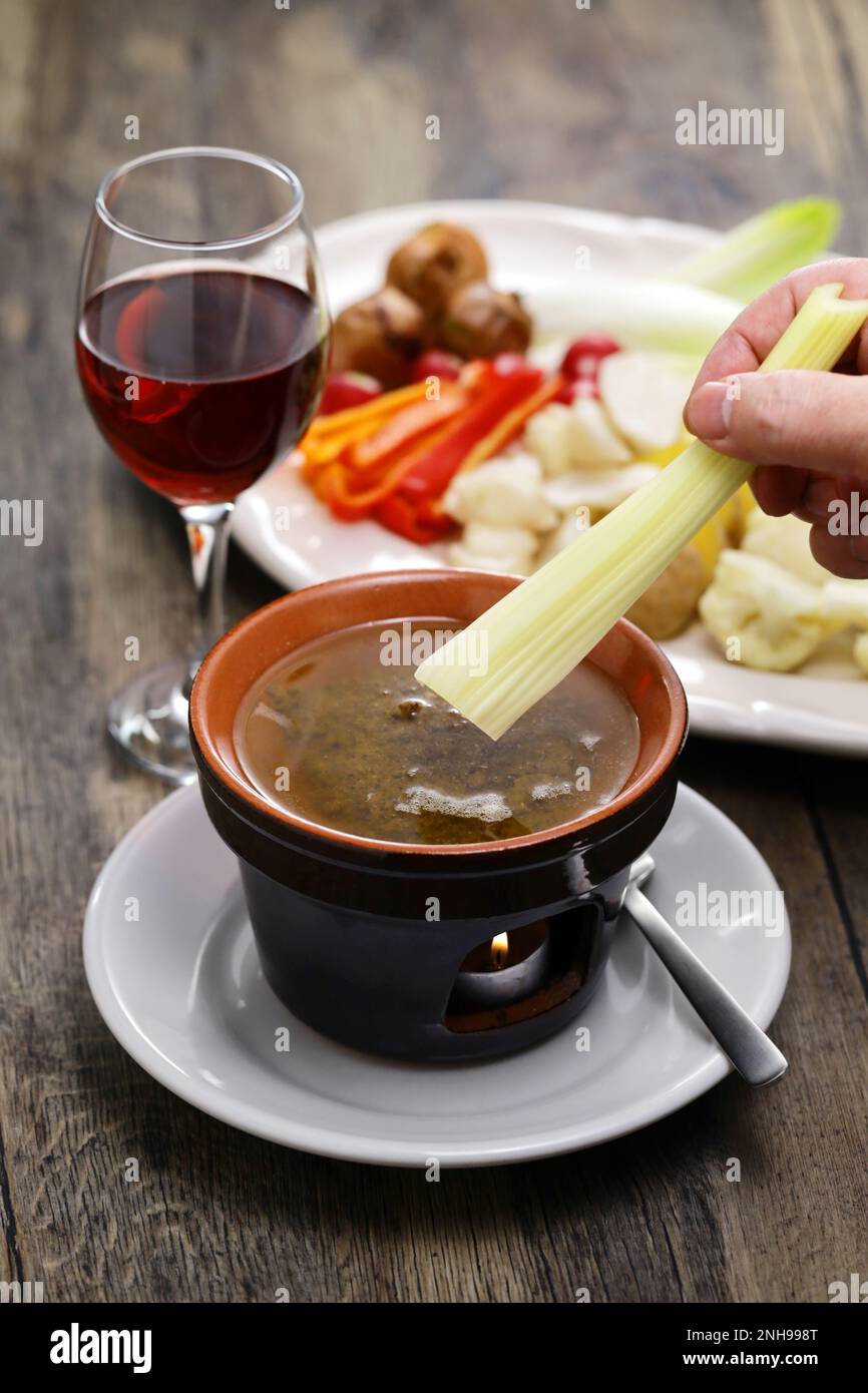 Sellerie eintauchen. Bagna Cauda (italienische Piemont-Küche) ist ein heißes Dip aus Knoblauch und Sardellen. Stockfoto