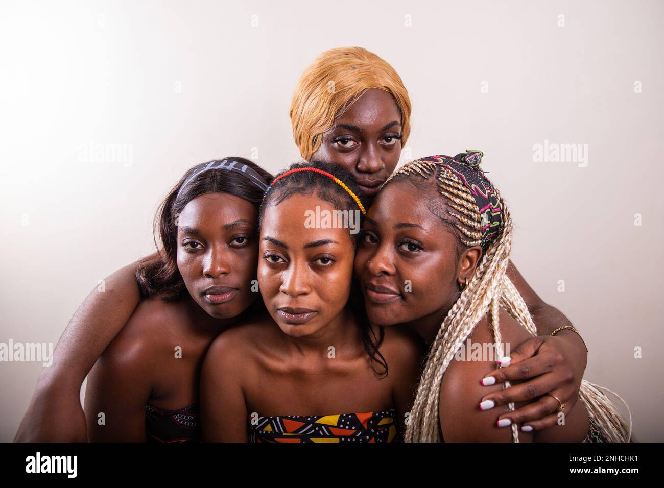 Vier afrikanische Frauen mit ernsten Ausdrücken schauen auf die Kamera, Studioaufnahme mit Kopierraum Stockfoto