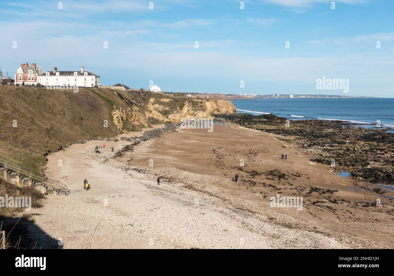 Leute, die am Strand in Seaham Harbour, Co., spazieren gehen Durham, England, Großbritannien Stockfoto