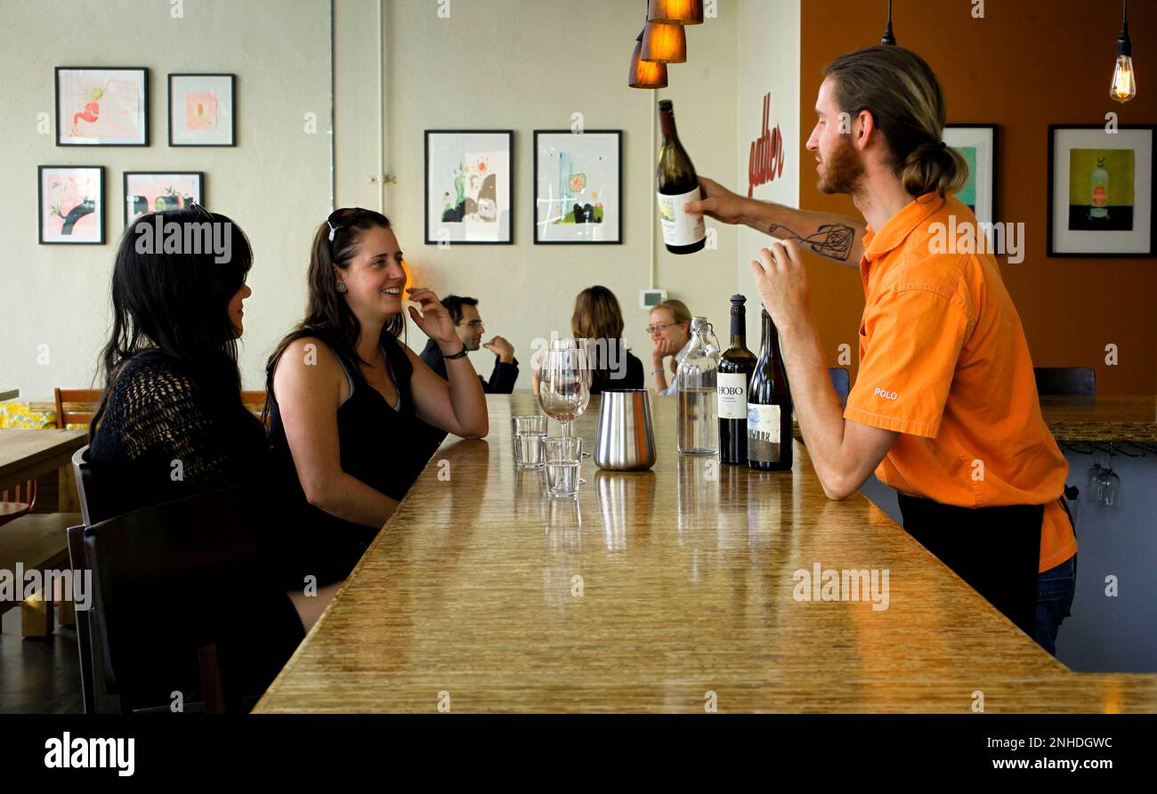 Sarah Brady, (left) and Aimee Voyde of Oakland, are served wine by August Beck at Encuentro restaurant near Jack London Square in Oakland, Ca. on Tuesday June 22, 2010. (Michael Macor/San Francisco Chronicle via AP) Stockfoto