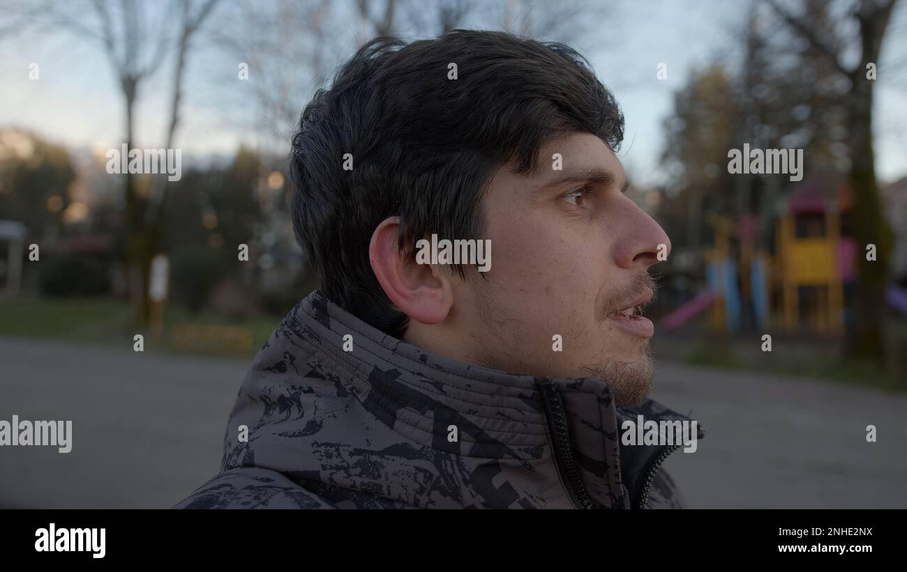 Ein nachdenklicher junger Mann in einem ruhigen Porträt mit Außenaufnahmen Stockfoto