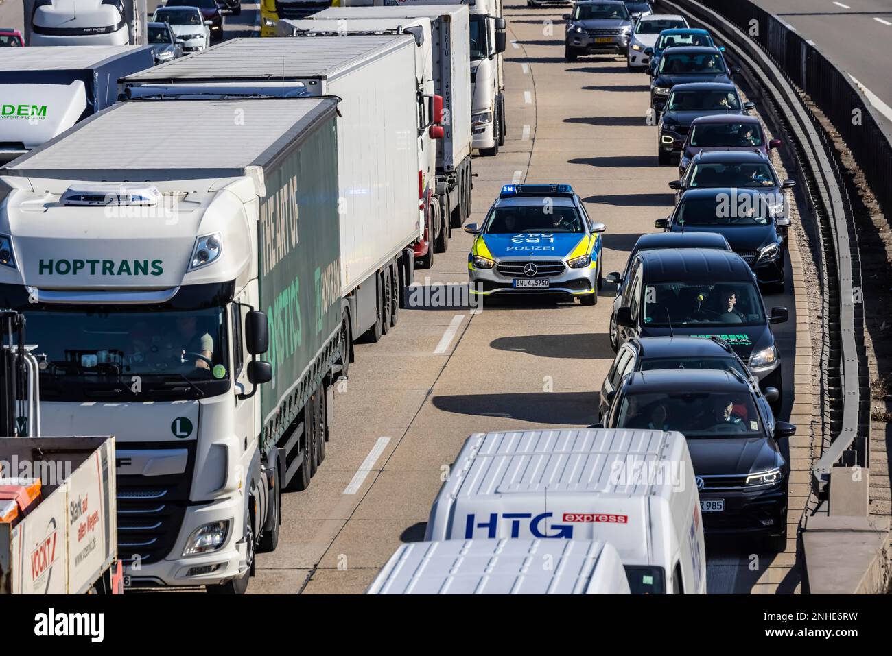 Autobahn A8 mit starkem PKW- und Lastwagenverkehr, Polizeiwagen fährt durch die Notspur, Sindelfingen, Baden-Württemberg, Deutschland Stockfoto