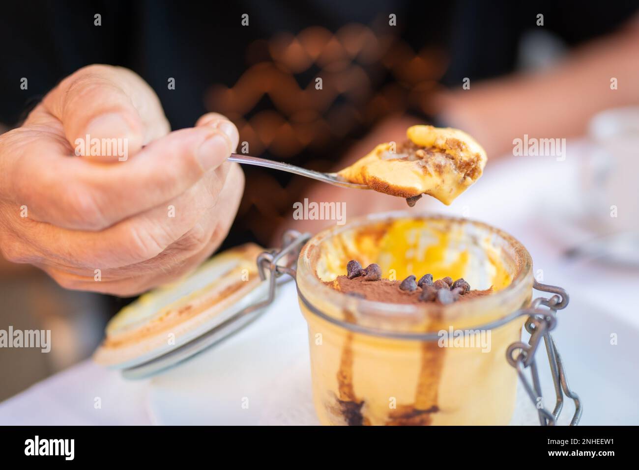 Traditionelles italienisches Dessert in einem Glasglas. Tiramisu auf einem Löffel. Traditionelles italienisches Dessert in einem Glasglas. Tiramisu auf einem Löffel. Stockfoto