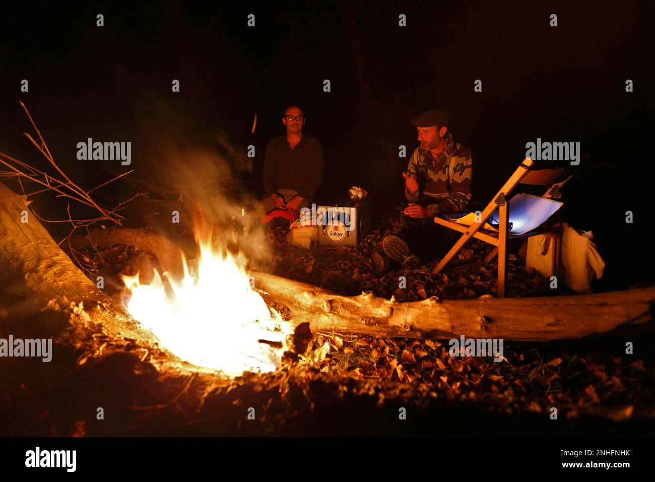 Am Abend im Lager am Feuer, zwei Männer am Lagerfeuer, Biosphärenreservat Mittelelbe, Dessau-Rosslau, Sachsen-Anhalt, Deutschland Stockfoto
