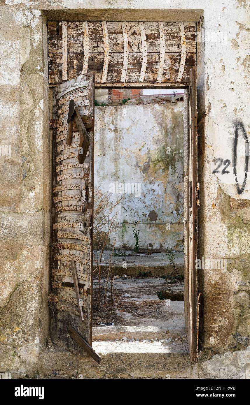 Das Innere eines Hauses in Ruinen, Blick durch die Tür, abblätterndes Gemälde, verfaulte Holztür Stockfoto