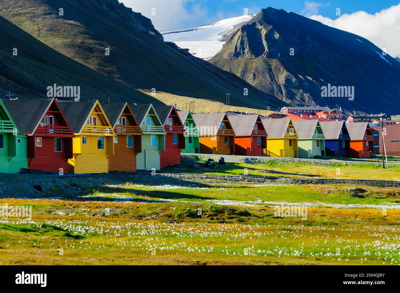 Eine Reihe sehr farbenfroher Häuser mit Bergen im Hintergrund in Longyearbyen, Svalsbard, Norwegen. Stockfoto