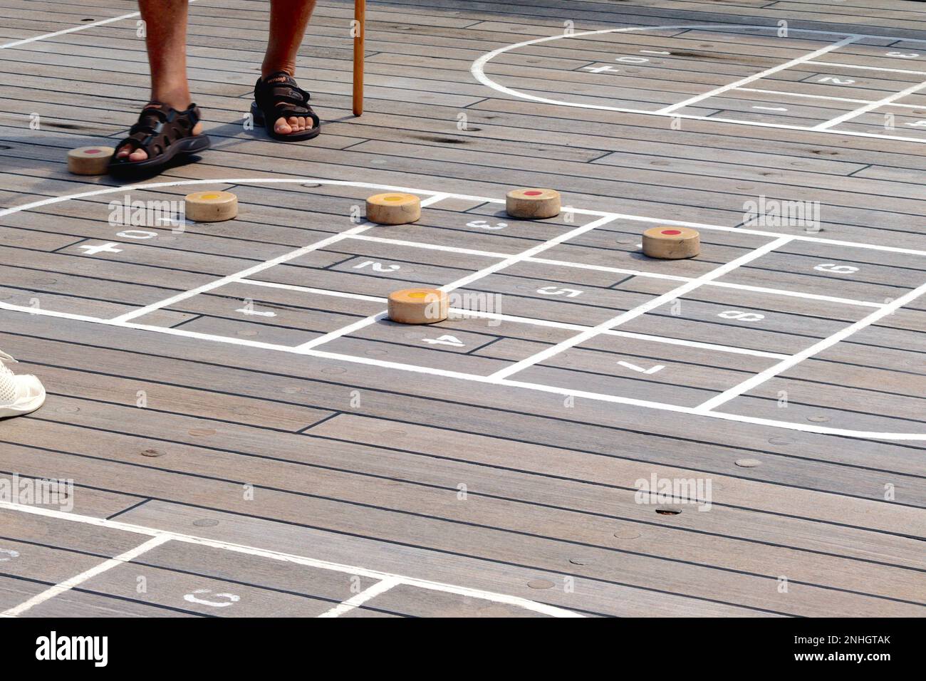 Die Spieler zählen den Punktestand während einer Runde Shuffleboard auf dem Sonnendeck des Kreuzfahrtschiffs Aurora, September 2022. Stockfoto