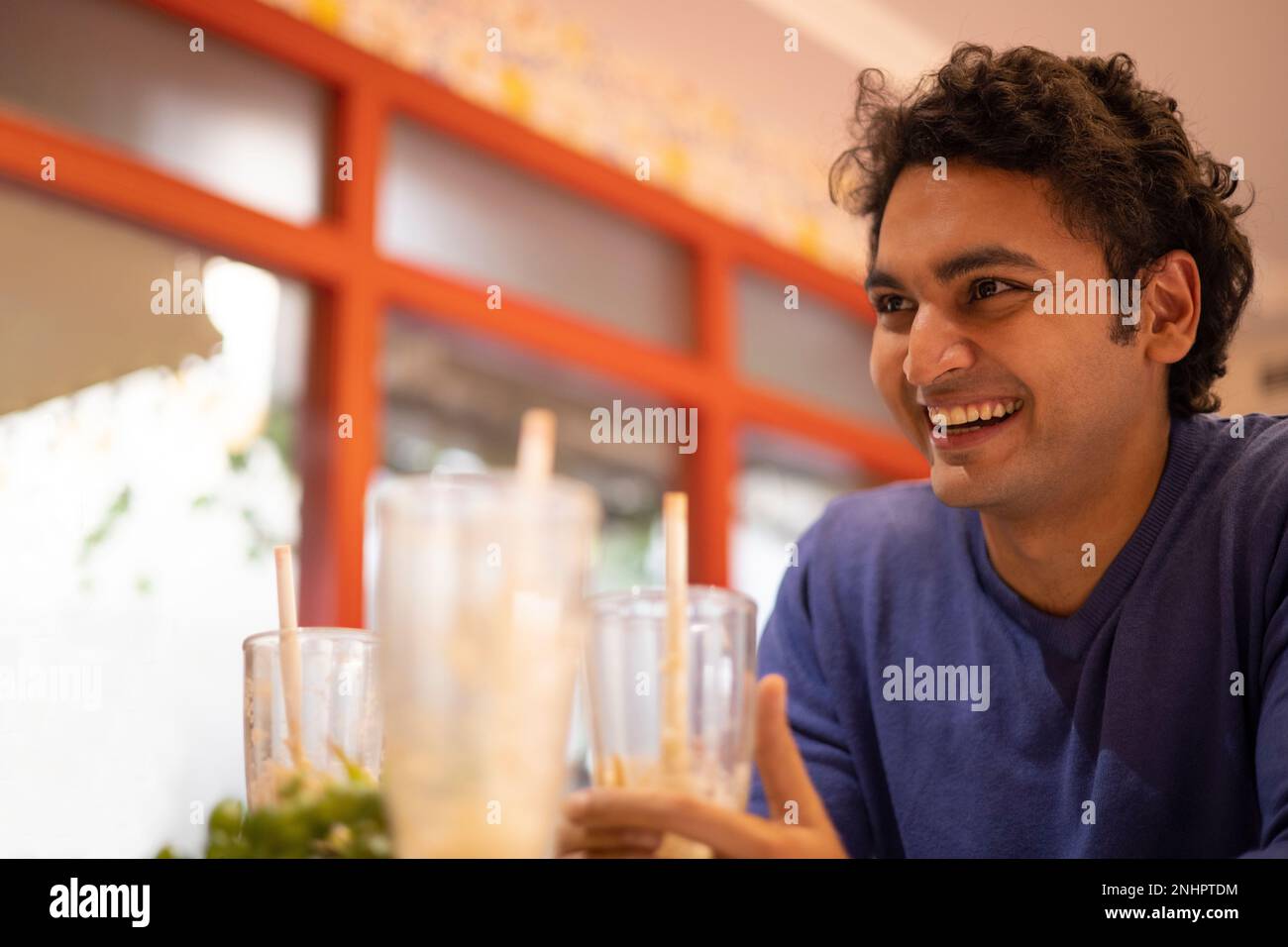 Nahaufnahme eines lächelnden Mannes, der im Café sitzt Stockfoto