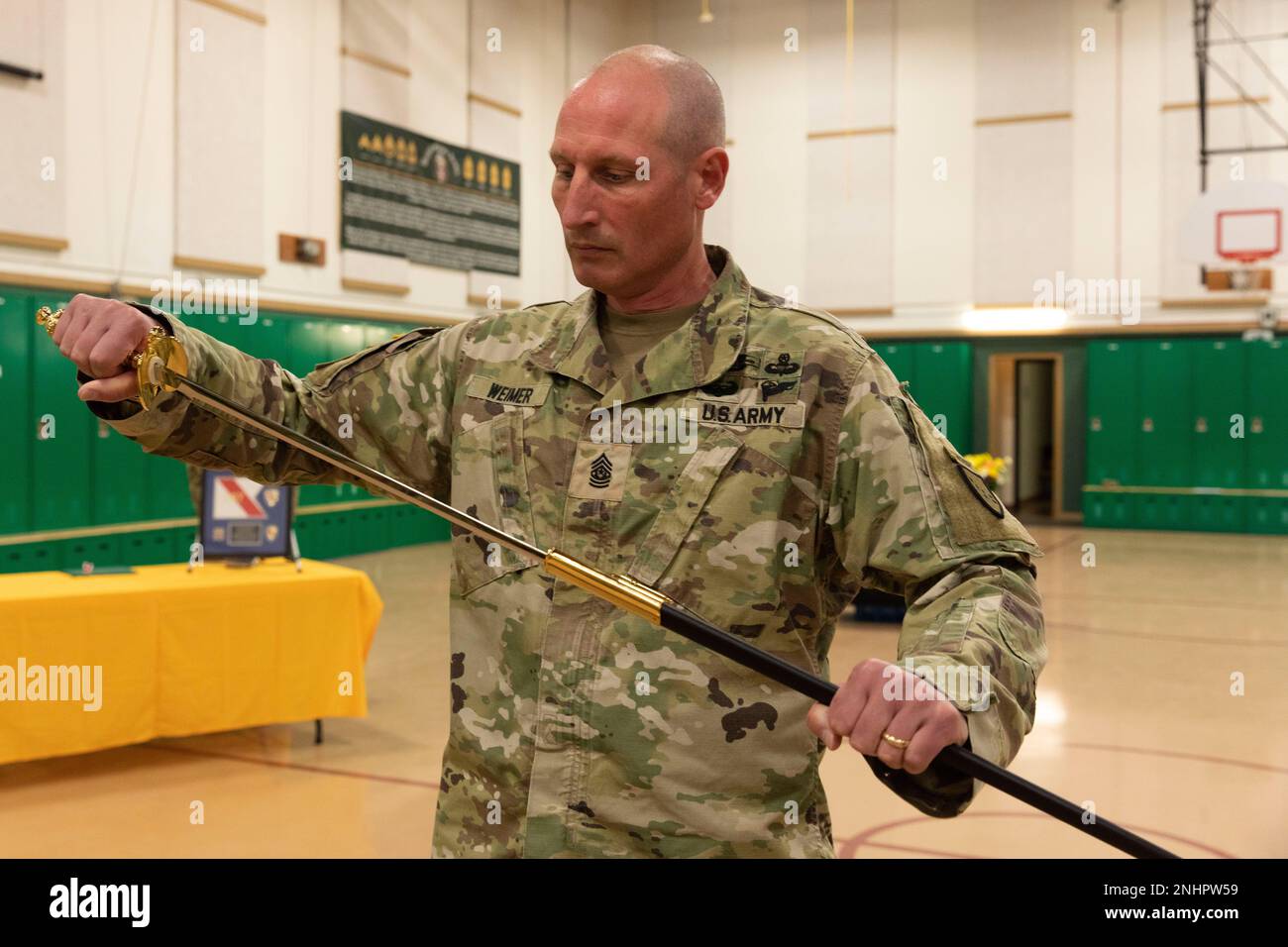 Alaska Army National Guard Command Sgt. Major Ryan Weimer enthüllt das Schwert während einer Zeremonie zum Verantwortungswechsel im Alcantra Armory in Wasilla, Alaska, 1. August 2022. Oberstleutnant Julie Small gab die Verantwortung als Oberbefehlshaber der 297. Regionalen Unterstützungsgruppe für Weimer auf. (Alaska National Guard Foto von Victoria Granado) Stockfoto