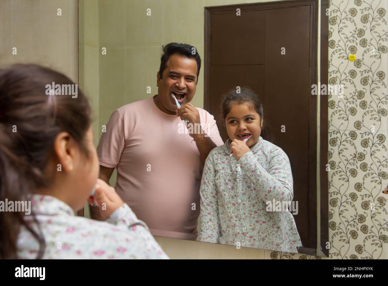 Vater und Tochter putzen zu Hause im Badezimmer Zähne zusammen Stockfoto