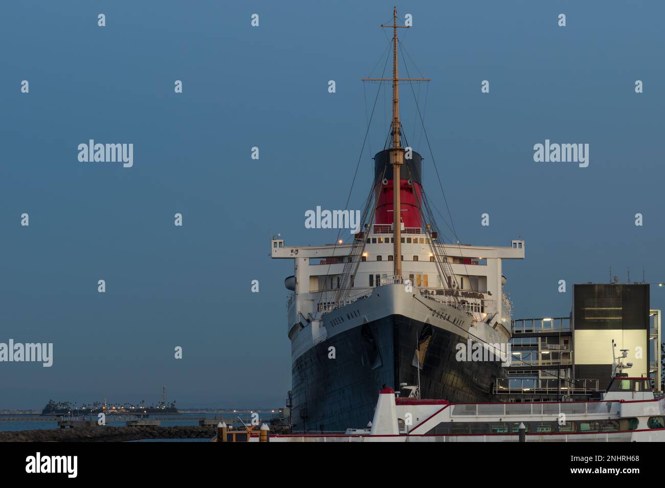 Long Beach, Kalifornien, USA - 20. Februar 2023: RMS Queen Mary bei Dämmerung im Hafen von Long Beach. Stockfoto