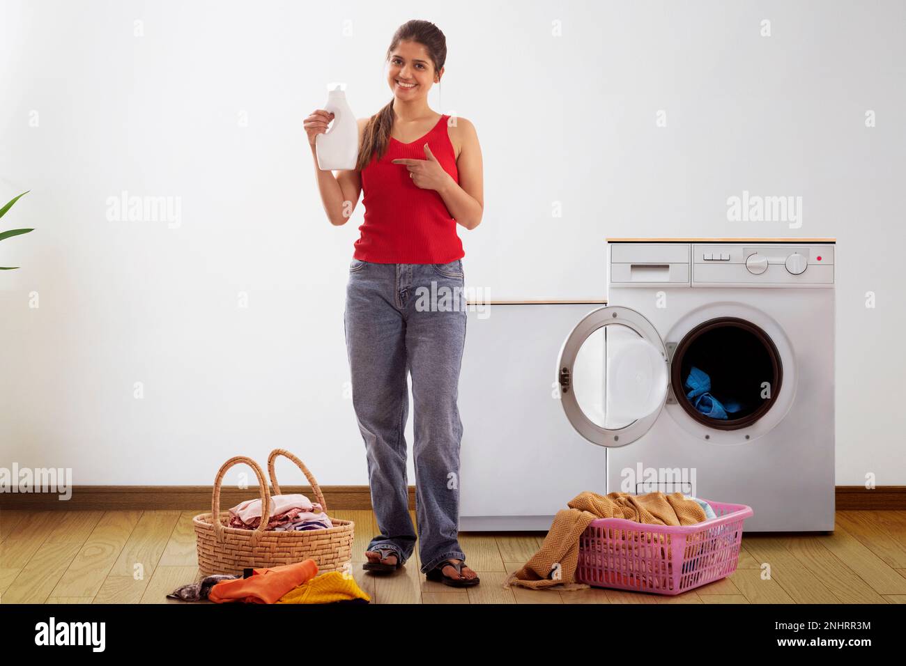 Junge Frau, die auf Waschmittel in der Hand zeigt Stockfoto