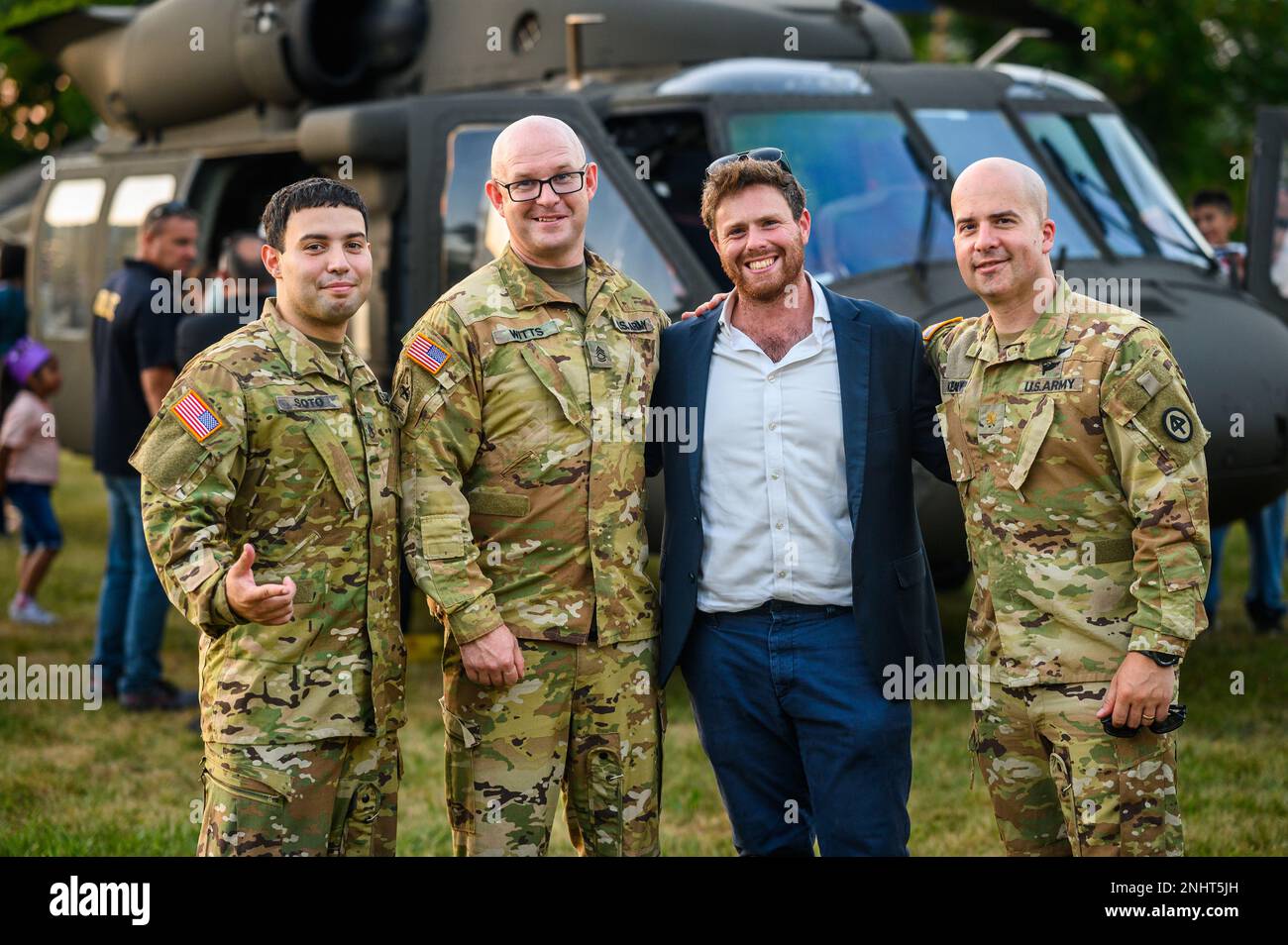 USA Feldwebel Xavier Soto, links, Feldwebel 1. Klasse Timothy Witts, zweiter von links, Und Major John J. Kealy, richtig, mit dem 1-150. Assault Helicopter Battalion, posieren mit einem Mitglied der Gemeinde während der National Night Out des Red Bank Police Department in Count Basie Fields in Red Bank, New Jersey, 2. August 2022. National Night Out ist eine jährliche Veranstaltung, die die Beziehung zwischen Nachbarn und Strafverfolgungsbehörden verbessern und gleichzeitig ein echtes Gemeinschaftsgefühl zurückbringen soll. Stockfoto