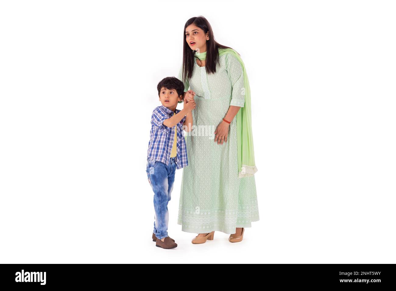 Porträt von glücklicher Mutter und Sohn, die vor weißem Hintergrund zusammenstehen Stockfoto