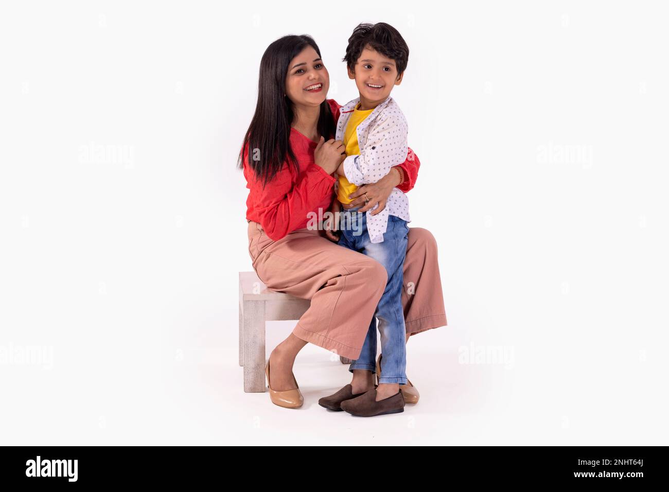 Porträt von fröhlicher Mutter und Sohn, die vor weißem Hintergrund wegschauen Stockfoto