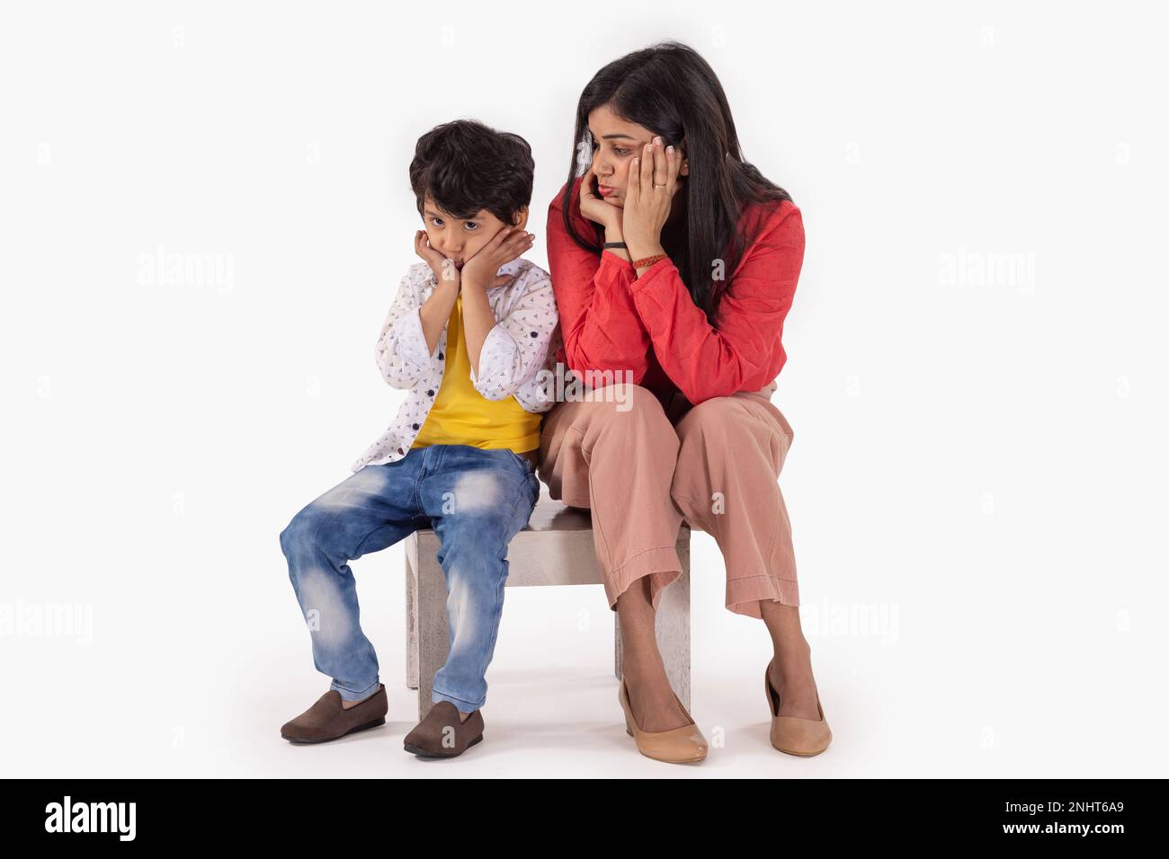 Mutter und Sohn Gesten mit Händen an der Wange vor weißem Hintergrund Stockfoto
