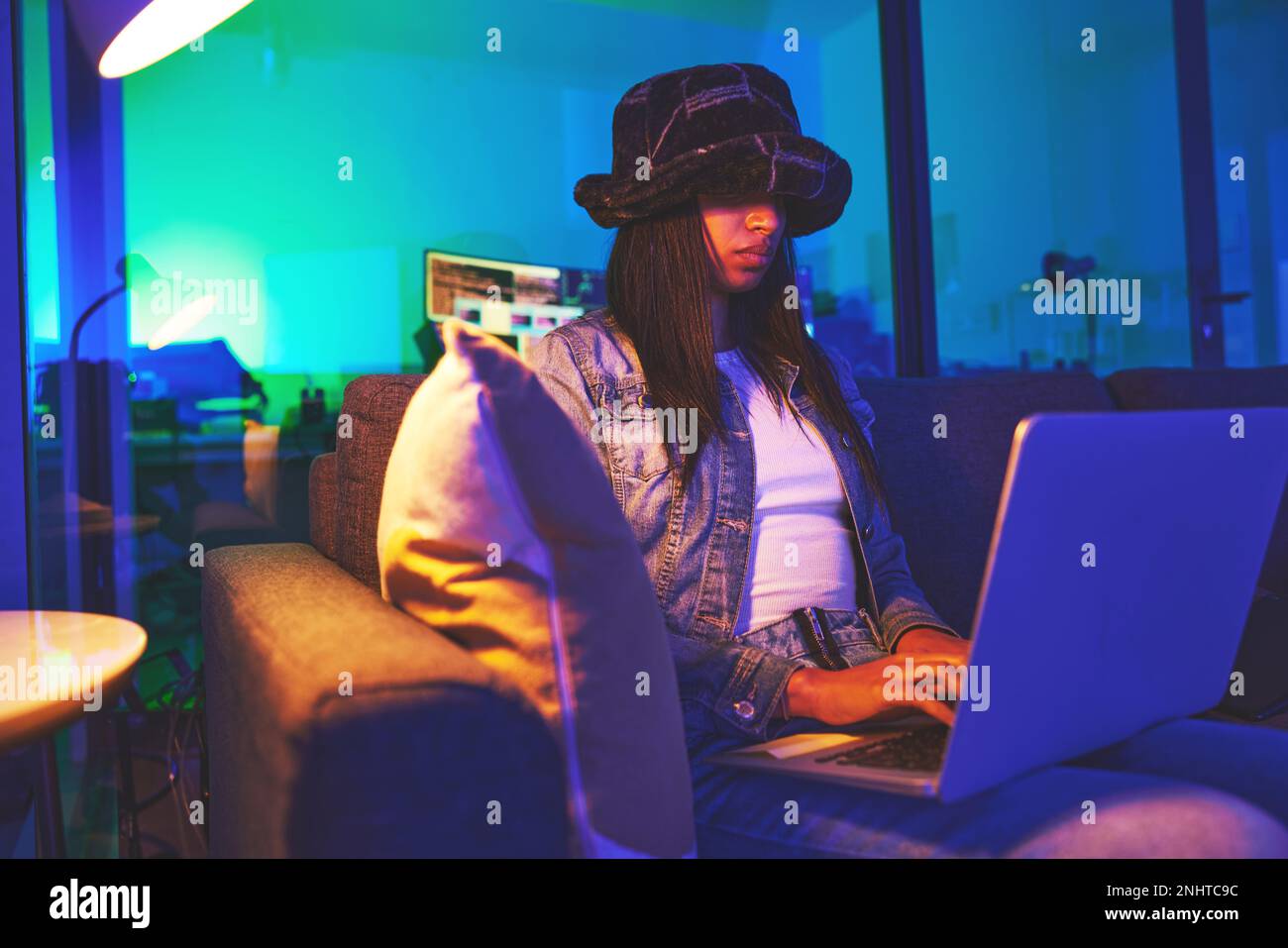 Programmierer, Hacker und Frau, die nachts zu Hause in Neonlicht auf einem Laptop tippen, um Software zu hacken. Cybersicherheit, Ransomware-Phishing und weiblicher Programmierer Stockfoto