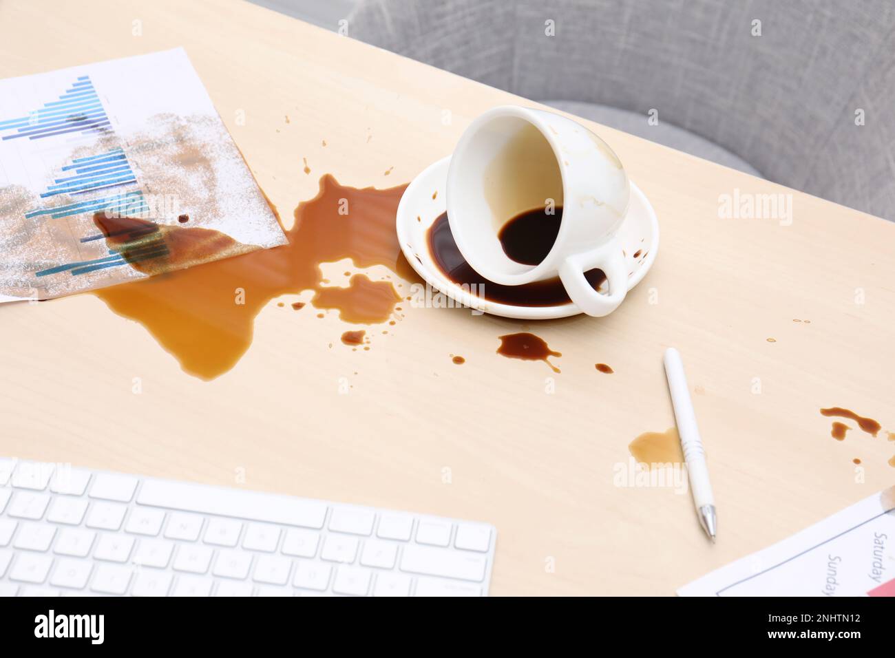 Tasse mit Untertasse und Kaffeeauslauf auf einem hölzernen Schreibtisch Stockfoto