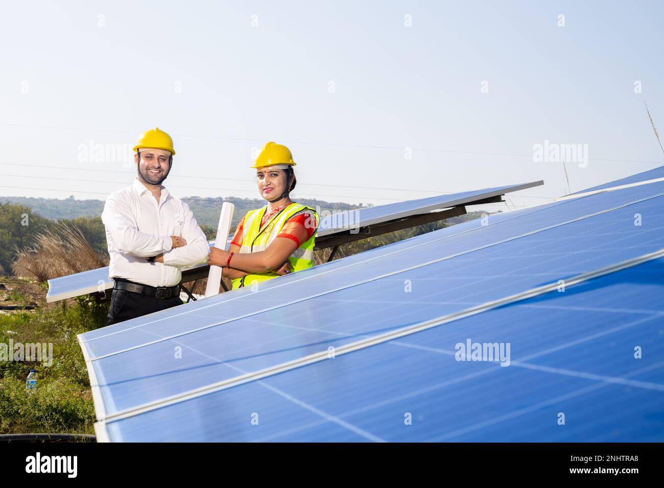 Porträt von jungen indischen Technikerinnen, die neben Solarpaneelen stehen. Industriearbeiter, Solaranlage, alternative erneuerbare grüne Energie Stockfoto
