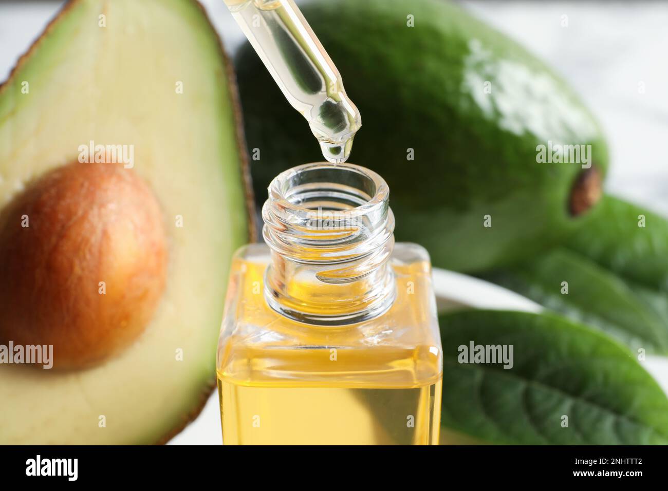 Ätherisches Avocado-Öl in die Flasche tropfen lassen, schließen Stockfoto