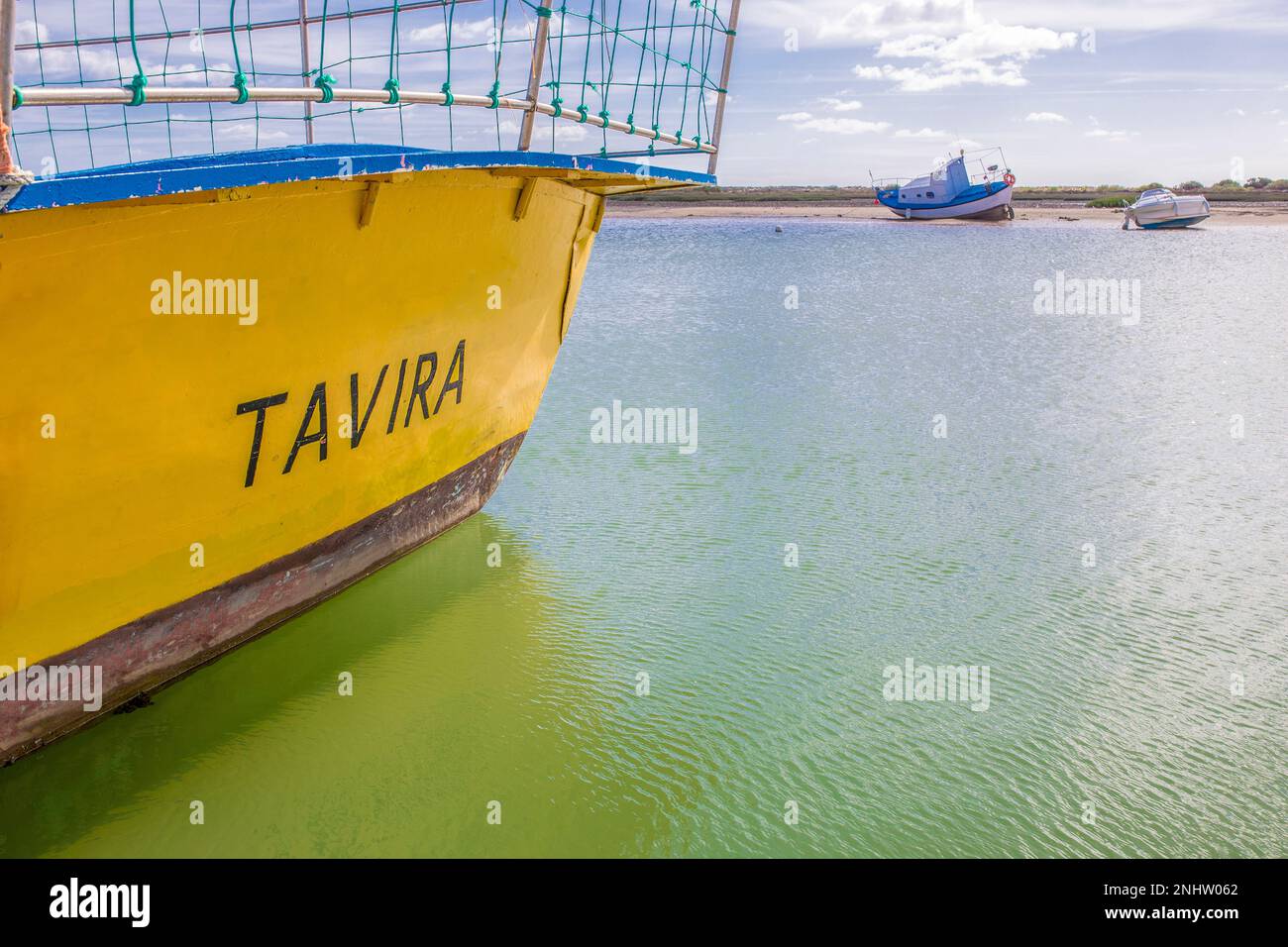 Traditionelles Fischerboot am Hafen von Cabanas de Tavira, Portugal. Tavira-Wort an der Seite gemalt Stockfoto