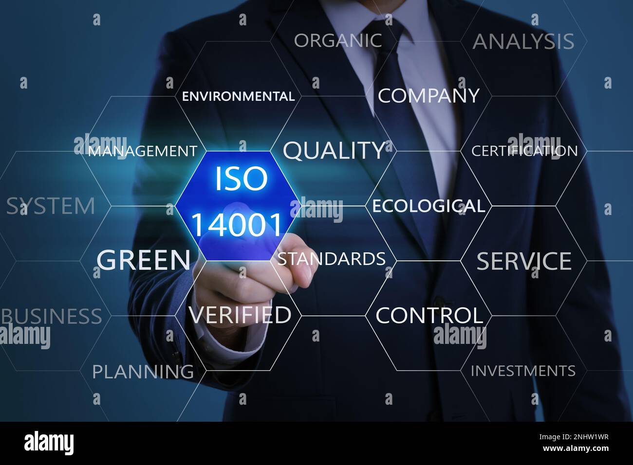 Geschäftsmann, der auf ein virtuelles Symbol zeigt, mit Text ISO 14001 auf farbigem Hintergrund, Nahaufnahme Stockfoto