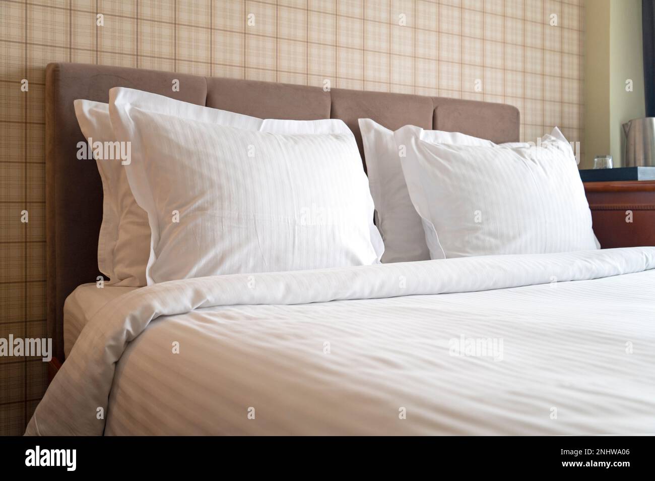 Komfortables Zimmer mit sauberer Bettwäsche, Kissen und Hoteleinrichtung Stockfoto