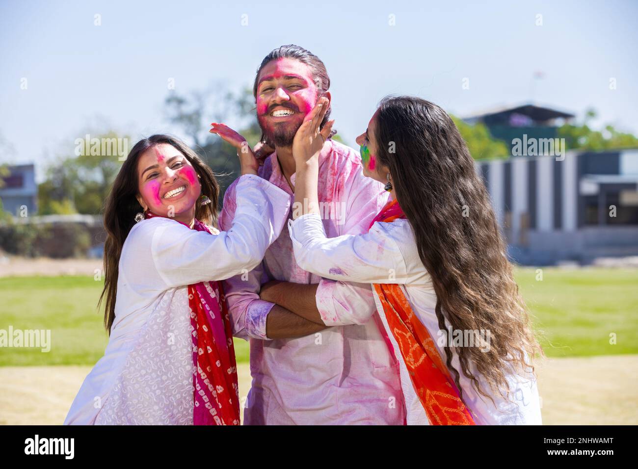 Fröhliche junge indische Familien spielen Fholi mit Farbpulver oder Gulal im Park. Stockfoto