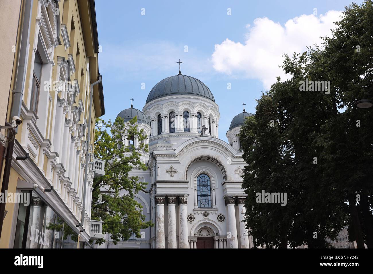 Dieses Foto zeigt die markante Vorderansicht der Kirche St. Michael der Erzengel in Kaunas, Litauen, aus der Sicht einer Straße mit Gebäuden auf t Stockfoto