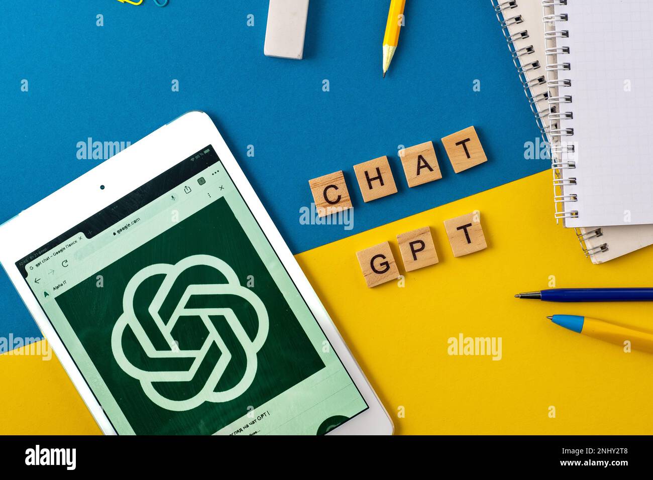 ChatGPT-Hintergrund. Wörter in Holzbuchstaben. Chatten Sie mit KI. Satz auf blauem Gelb. Logo auf iPad. Arbeiten und Lernen mit gpt. Website auf dem Smartphone. Chatbot OpenAI. Ukraine, Kiew - 21. Februar 2023 Stockfoto