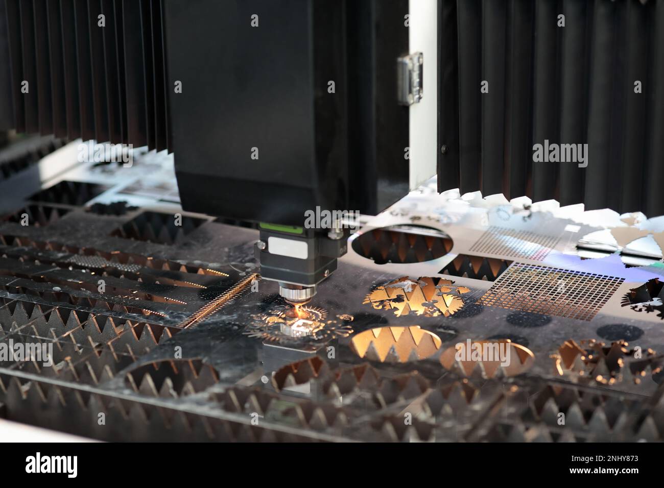 Blechschnitt aus Edelstahl mit CNC-Laserschneidemaschine. Selektiver Fokus. Stockfoto