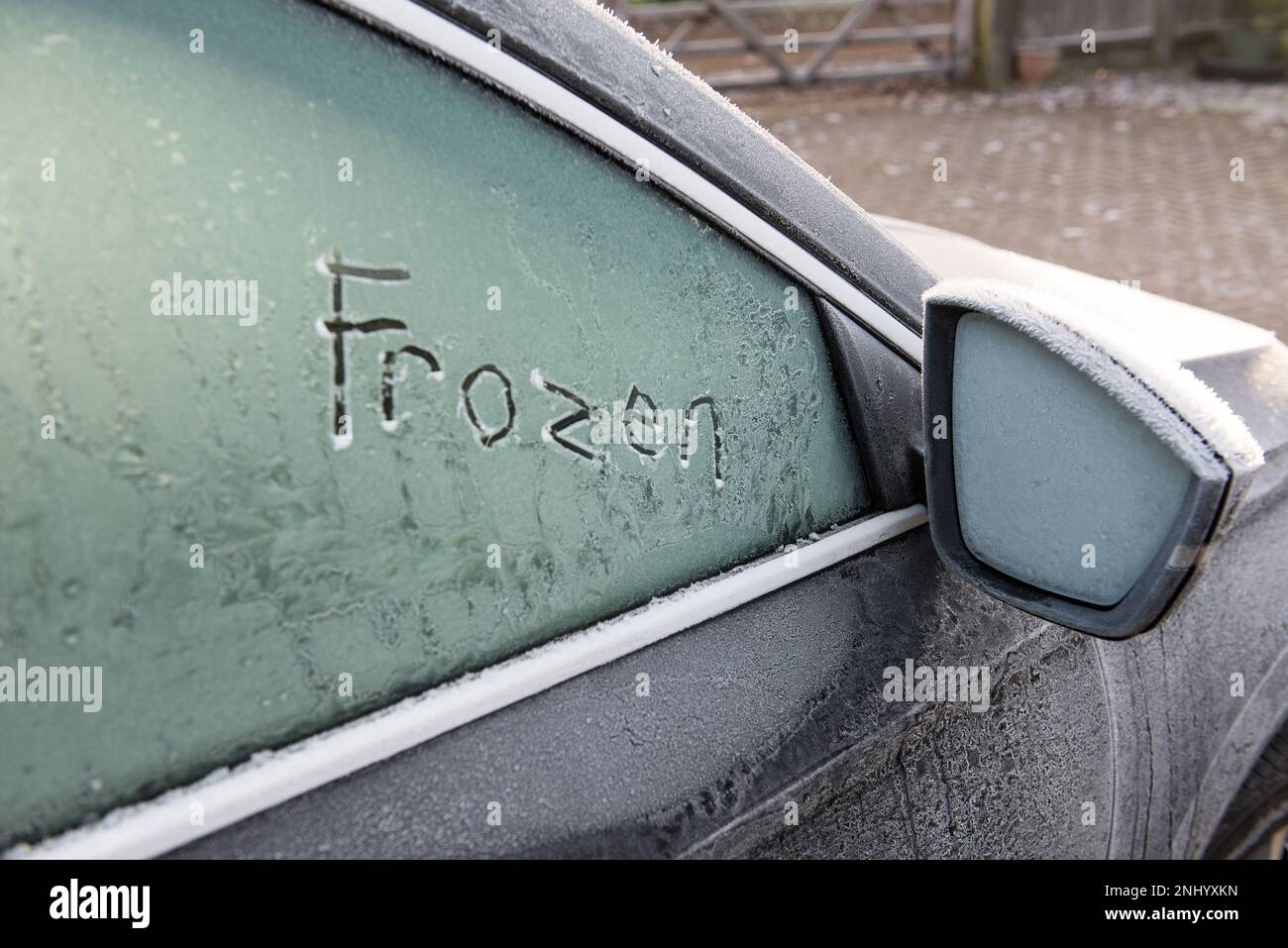 Harter Frost und Temperaturen unter Null lassen Sie die Windschutzscheibe des Fahrzeugs mit einer Schicht Frosteis bedeckt, die vor der Fahrt entfernt werden muss. Meldung „kalt gefroren“ Stockfoto