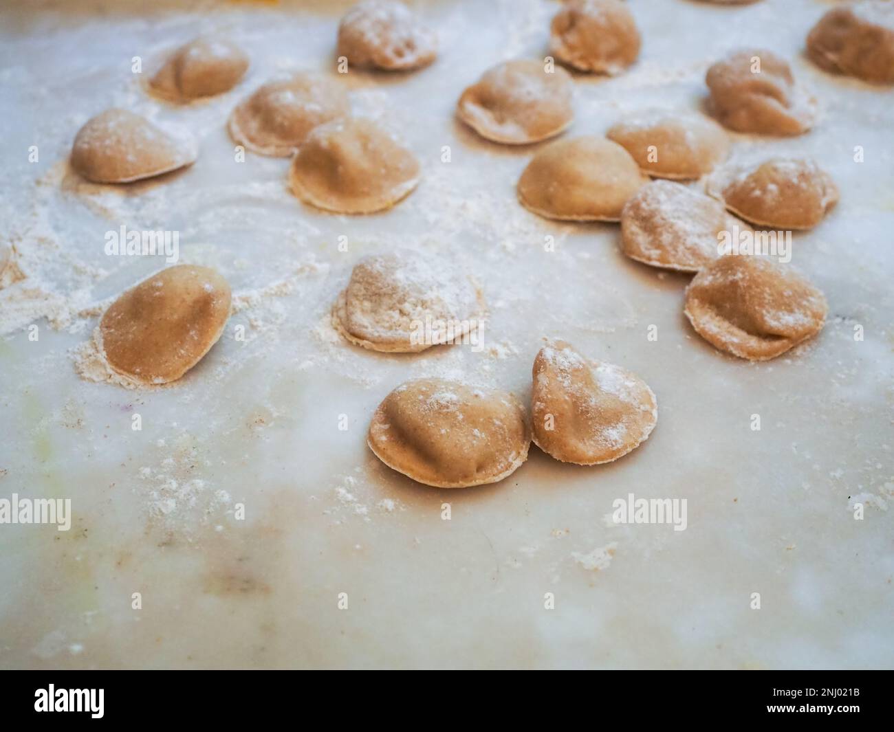 Nahaufnahme: Tortelli gefüllt mit Kürbis gefüllt mit hausgemachter Pasta, Oma kocht saisonale „Tortelli di zucca“, traditionelle italienische gefüllte Pas Stockfoto