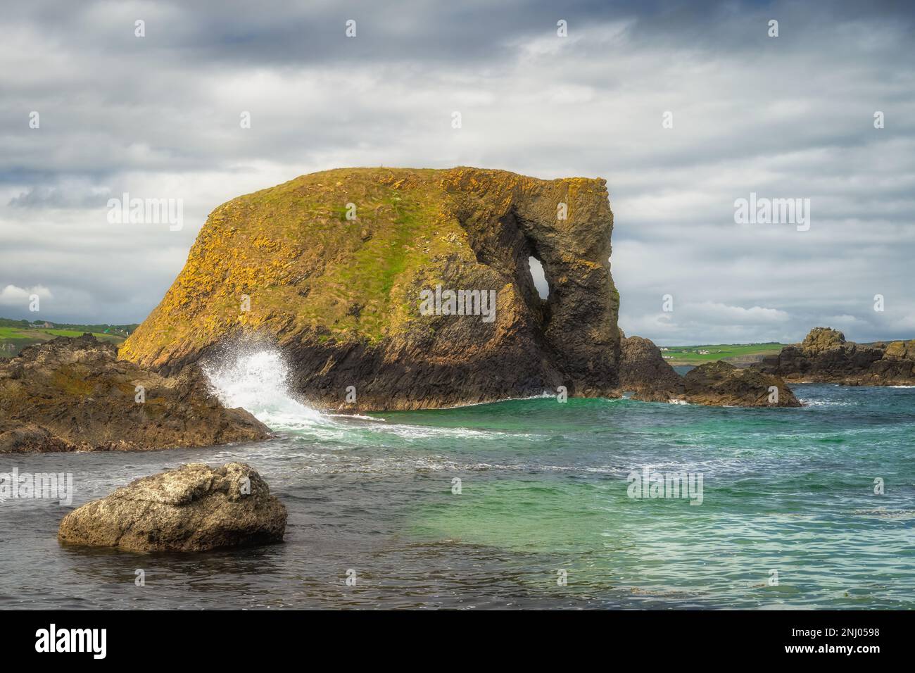 Wunderschöne Küstenfelsformation, Elefantenfelsen mit planschenden Wellen und türkisfarbenem Wasser auf einem Wild Atlantic Way in Country Antrim, Nordirland Stockfoto