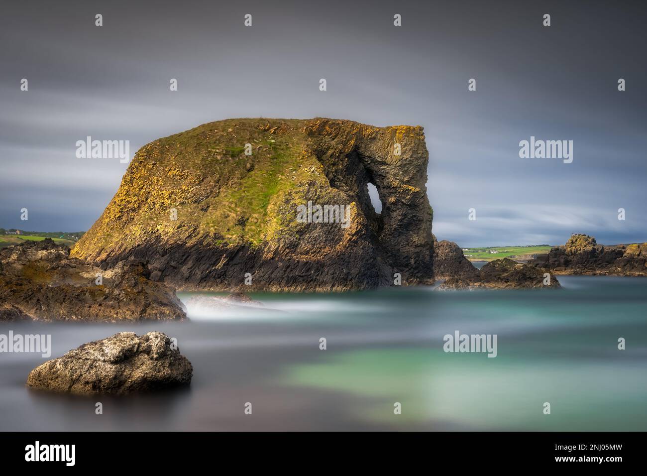 Wunderschöne Küstenfelsformation, Elefantenfelsen auf lange Sicht mit verschwommenem Wasser und Himmel, Wild Atlantic Way in Country Antrim, Nordirland Stockfoto