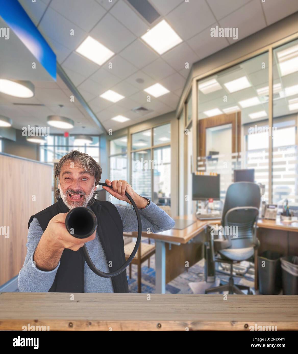 Taubstummer, weißer Mann mit altem Gerät im Büro Stockfoto