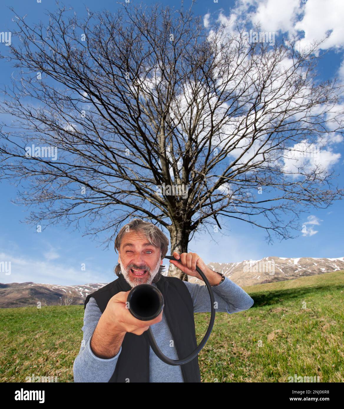 Taubstumme Idee, weißer Mann mit altem Gerät über wunderschöner Landschaft Stockfoto