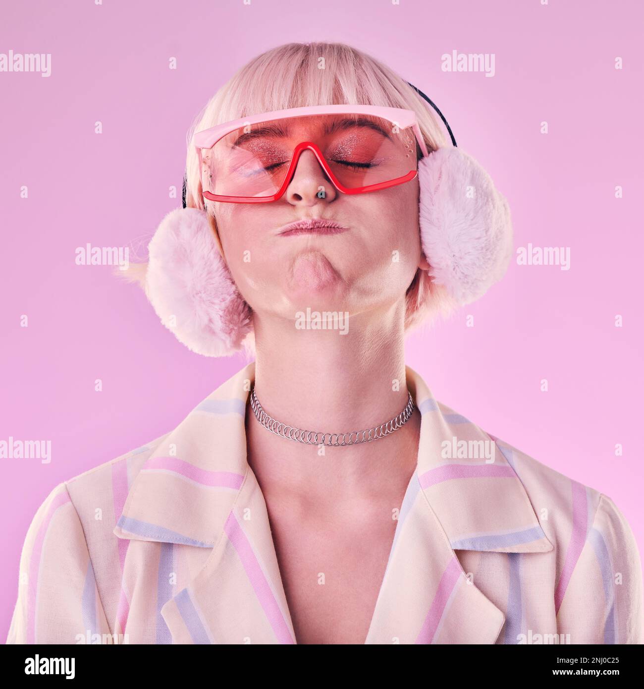 Mode, Frau und eigenartig auf pinkfarbenem Hintergrund im Studio mit lustigen Brillen für den Cyberpunk-Stil. Gesicht einer trendigen, trendigen oder Retro-ästhetischen Person mit Stockfoto