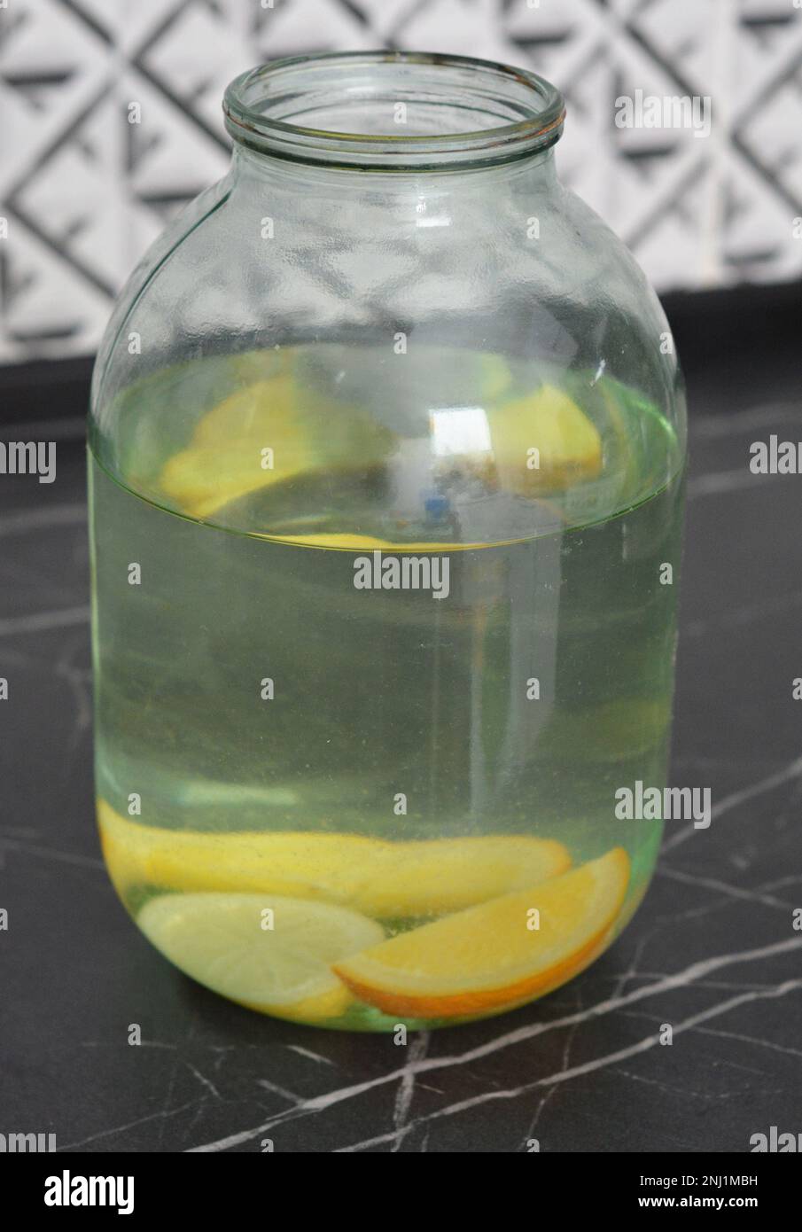 Nahaufnahme eines süßen Getränks, das auf der Basis von birkensaft mit Zitrone, Orangenscheiben und Zucker in einer Getränkedose zubereitet wird. Stockfoto